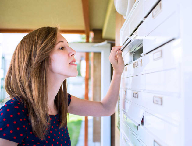 Žena hledá v poštovní schránce